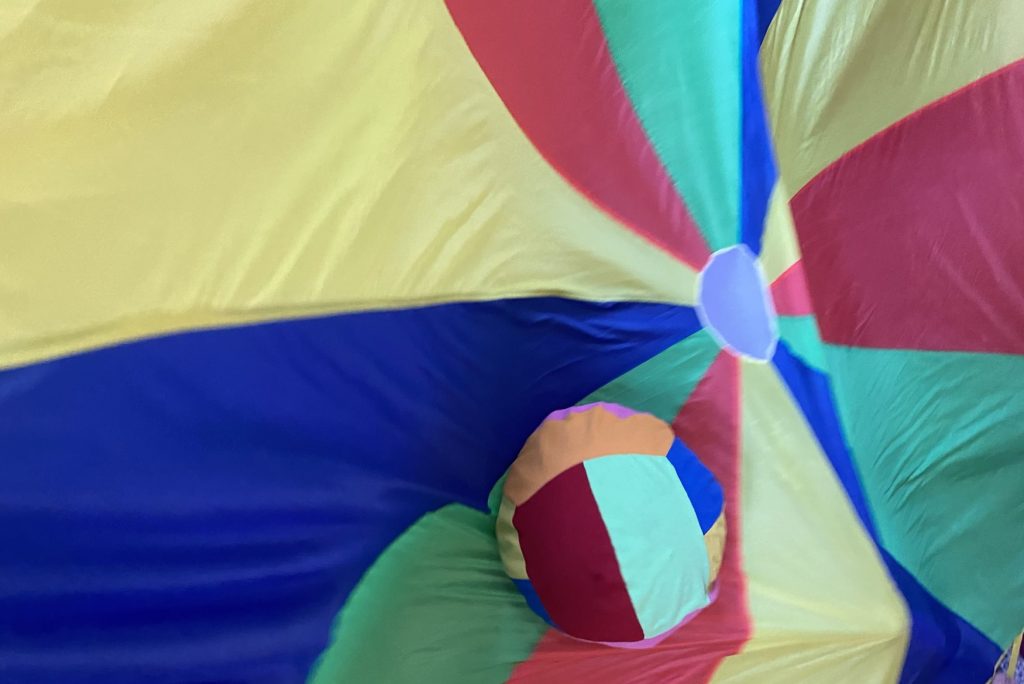 Practical movement task in a group with a parachute